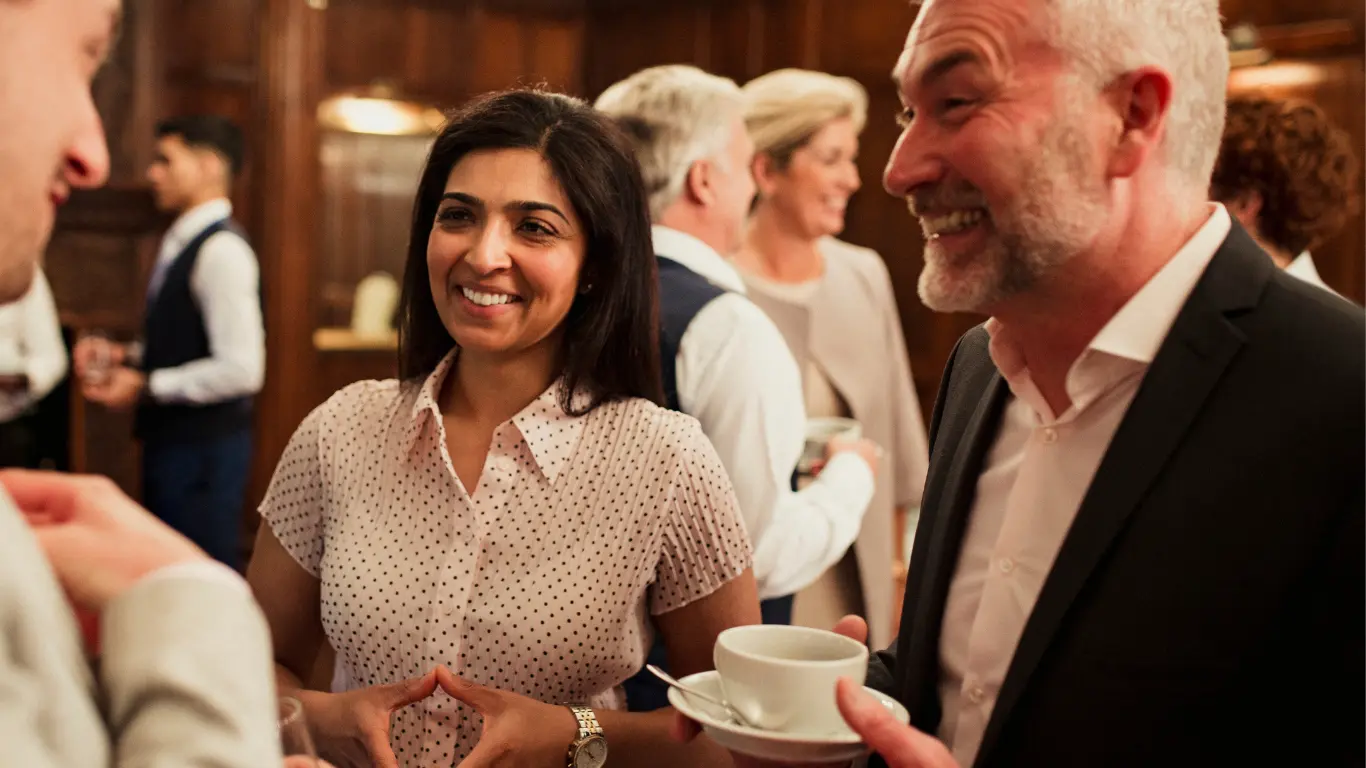 2 men and 1 woman in conversation at a networking event