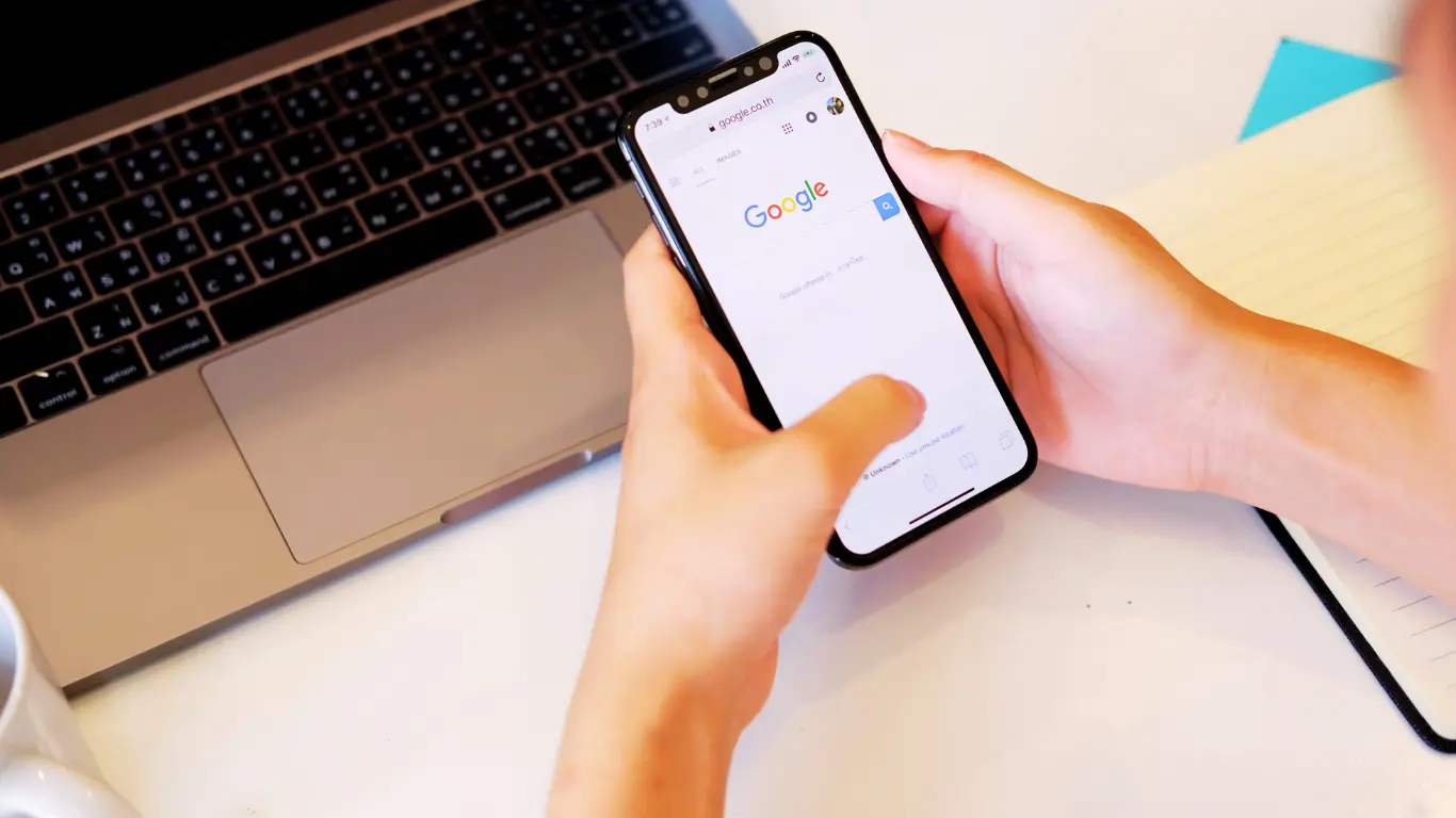 person holding a mobile phone showing  google search results