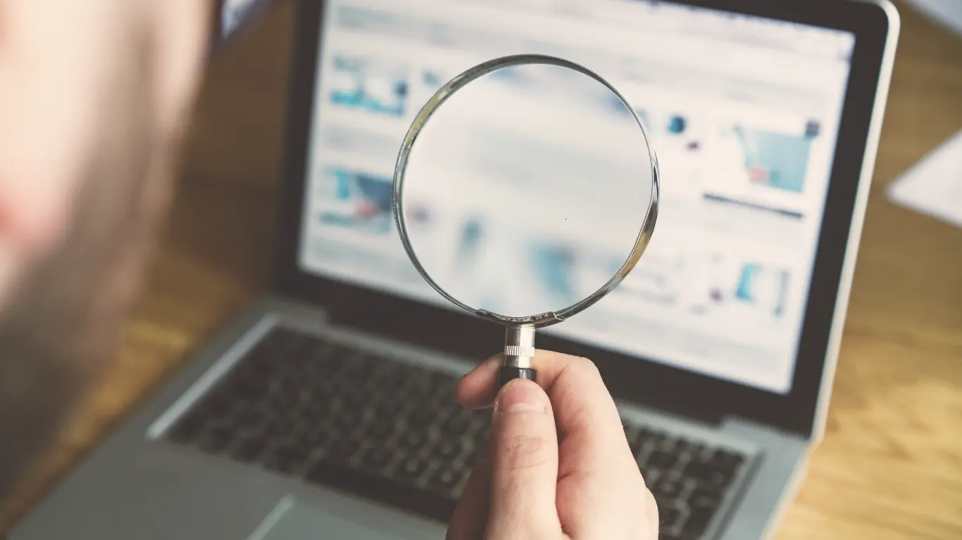 Magnifying glass in front of a laptop search results window