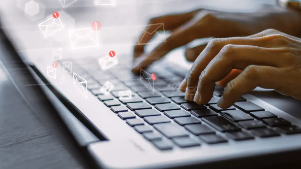 fingers tapping a laptop keyboard, creating an email marketing strategy