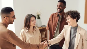 a group of people with 2 people shaking hands, demonstrating alliances and introducers