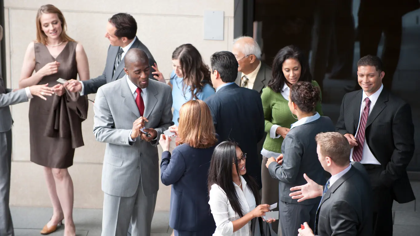 large group of people talking at a networking event 