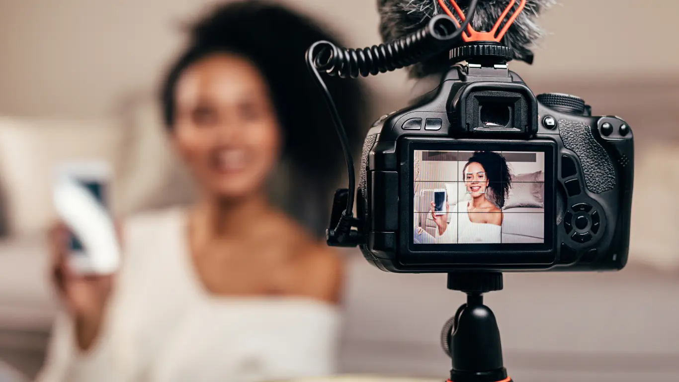 female being filmed with a camera to create video content