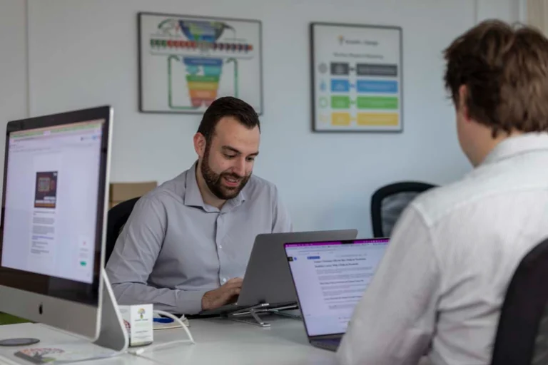 Growth by Design marketing managers sat at laptops created marketing strategies for clients
