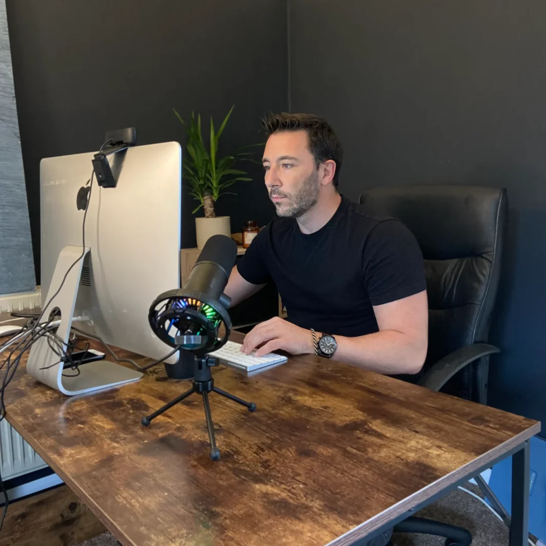 Chris working at wooden desk on a website